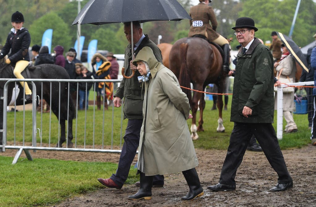 Schlechtes Wetter? Es gibt nur schlechte Kleidung! Die Queen besucht das Turnier ein Jahr später bei Regen.