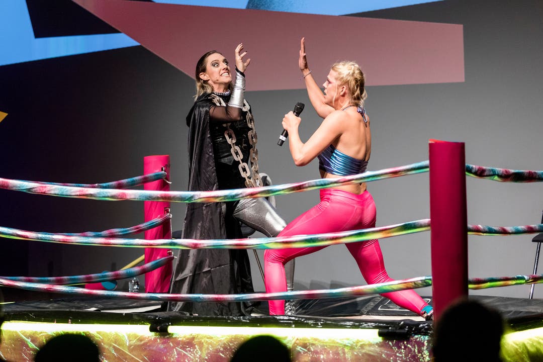 Bühnenkünstlerin Jane «the Pain» Mumford im schwarzen Superheldinnen-Umhang mit silbernen Leggins und Schauspielerin Momo «the Maniac» Kunz in pinker Powerfrau-Lederkluft steigen in den Wrestlingring.