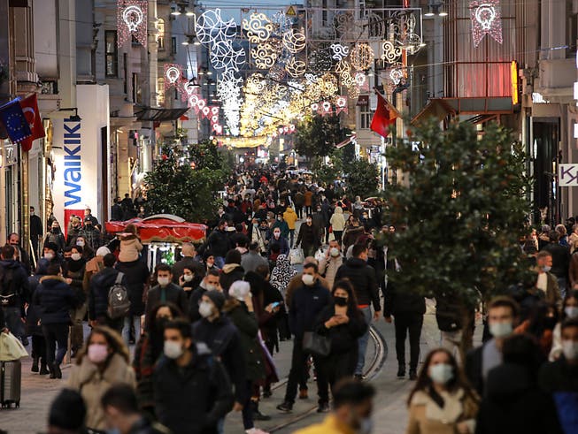 Menschen spazieren wenige Stunden vor der Sperrstunde entlang der Haupteinkaufsstrasse in Istanbul. Die türkische Regierung hat entgegen der bisherigen Praxis die täglichen Fallzahlen der positiv auf das Coronavirus getesteten Menschen im Land bekanntgegeben. Foto: Emrah Gurel/AP/dpa