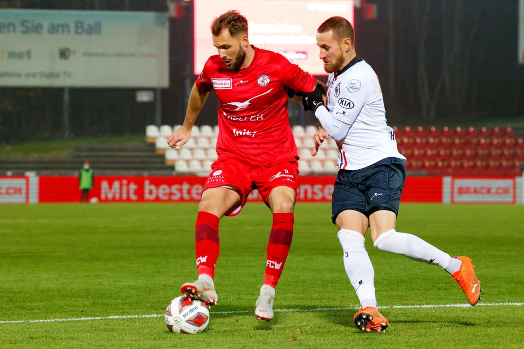 Winterthur-Stürmer Roman Buess deckt gegen FCA-Verteidiger Thiesson den Ball ab.