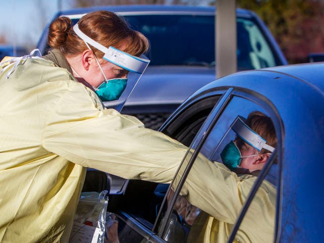 ARCHIV - Eine Mitarbeiterin des Gesundheitswesens führt einen Corona-Test bei einem Patienten auf dem Parkplatz des Saint Alphonsus Health Plaza durch. Foto: Darin Oswald/Idaho Statesman/AP/dpa