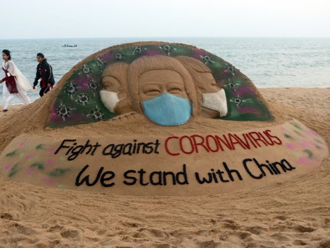 Solidaritäts-Sandskulptur des indischen Künstlers Sudarsan Pattnaik für China. Im Reich der Mitte ist die Corona-Pandemie extrem verniedlicht worden, wie eine neue Studie beweist.