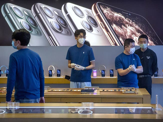 Angestellte in einem Apple-Store in Peking tragen wegen des Coronavirus Atemmasken.