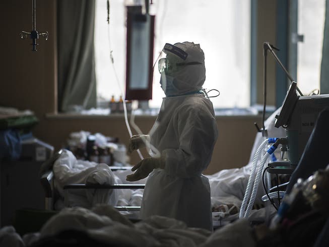 Eine Krankenschwester in Schutzkleidung betreut Patienten im Zentrum des Coronavirus-Ausbruchs in der Stadt Wuhan. (Foto: Xiao Yijiu/AP Keystone-SDA)