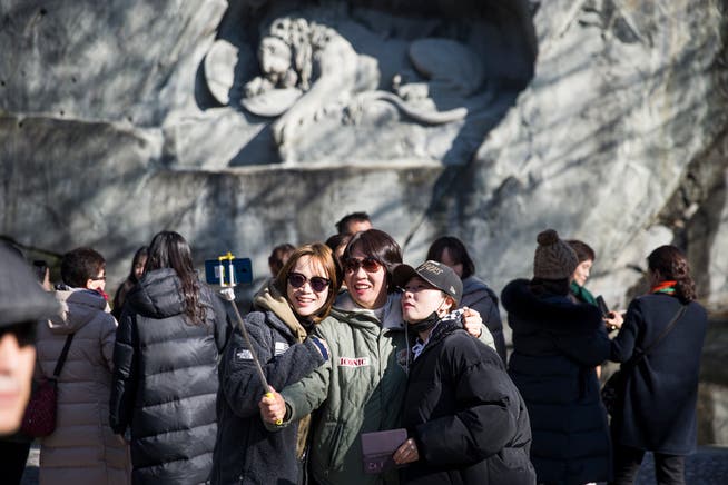 Eine Gruppe asiatischer Touristen vor dem Löwendenkmal in Luzern.