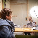 Getrennt durch eine Scheibe, verbunden per Telefon: Trudi Jäger unterhält sich mit ihrer Mutter Hilda Schläpfer in der Besuchsbox des Alters- und Pflegeheims Risi. (Ralph Ribi)