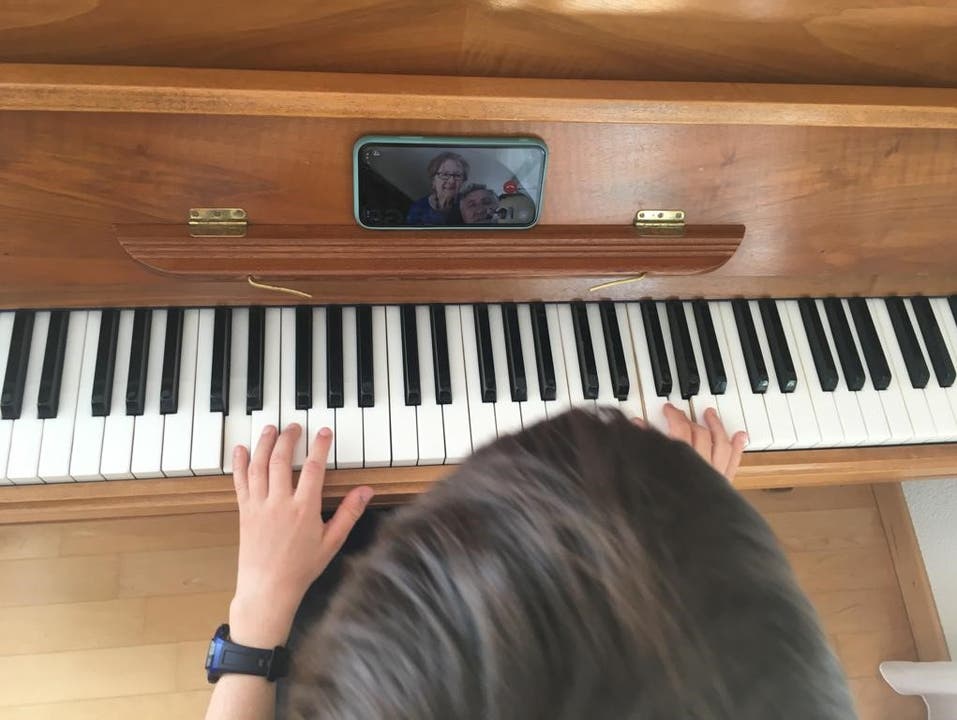 Ein Kind spielt seiner Grossmutter ein Stück am Klavier vor.