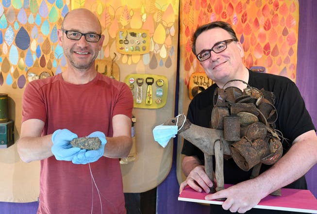 Archäologe Martin Berweger mit dem Steinzeitbeil und Grafiker Peter Halter mit einem Holzross samt Maske.