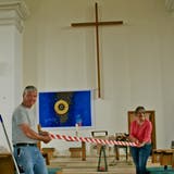 Boden markieren und Sitzplätze punktieren: Die Mesmer Werner Häne und Heidi Ünes rüsten die Kirche Wattwil aus. (Bild: PD)