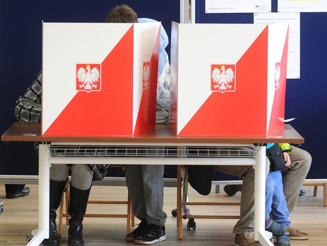 Wähler hinter Wahlurnen in der polnischen Hauptstadt Warschau.