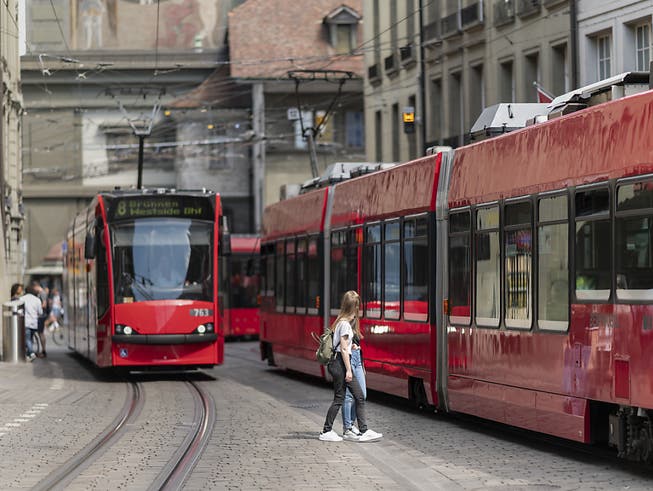 Zwei Trams kreuzen sich in der Stadt Bern in der Marktgasse.