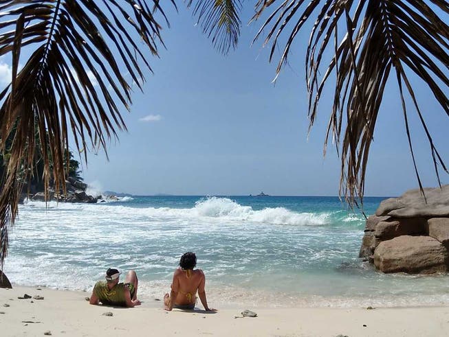 ARCHIV - Touristen liegen am Strand der Seychelleninsel La Digue. Foto: Sabrina Hentschel/dpa