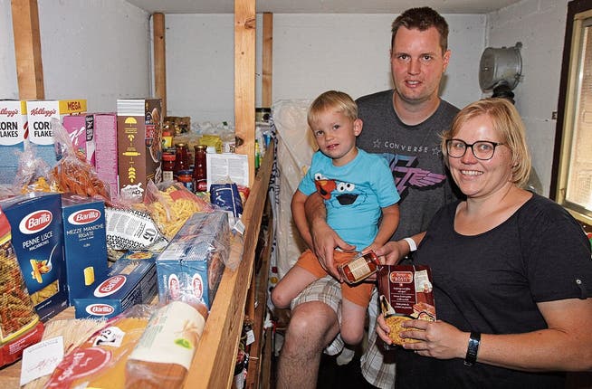 Sebastian Krause, Jasmine Kretz and their son Simon in the air raid shelter where they store their supplies.