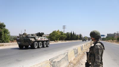 epa08520481 A soldier watches on as a tank of the Russian-Turkish joint Military patrols No. 19 drive on the M4 road linking Tranbah village to the Town of Jisr Al-Shughour, in The outskirts of Ariha south of Idlib, Syria, 01 July 2020.  The EU and the UN co-chaired, on 30 June,  the fourth Brussels Conference to seek a political solution to the Syria conflict, raise financial support for Syria and the countries in the region that host Syrian refugees.  EPA/YAHYA NEMAH (Yahya Nemah / EPA)