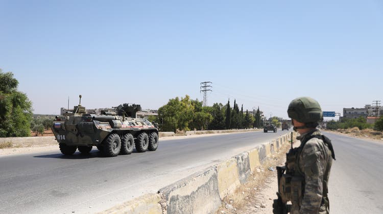 epa08520481 A soldier watches on as a tank of the Russian-Turkish joint Military patrols No. 19 drive on the M4 road linking Tranbah village to the Town of Jisr Al-Shughour, in The outskirts of Ariha south of Idlib, Syria, 01 July 2020.  The EU and the UN co-chaired, on 30 June,  the fourth Brussels Conference to seek a political solution to the Syria conflict, raise financial support for Syria and the countries in the region that host Syrian refugees.  EPA/YAHYA NEMAH (Yahya Nemah / EPA)