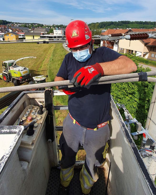 Einsatz mit Maske: Ein AEW-Arbeiter ersetzt alte Kabel im Gebiet Lenzhard in Lenzburg.