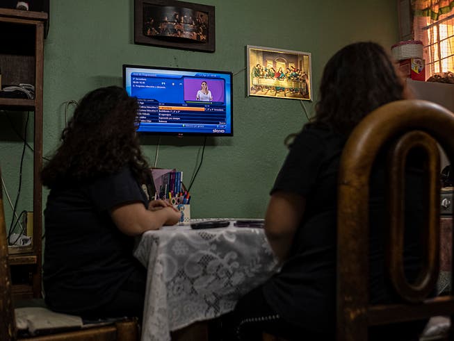 ARCHIV - Die 13-jährigen Zwillinge Ana Vanesa und Maria Fernanda verfolgen den Unterricht im Fernseher, als das neue Schuljahr wegen der Corona-Pandemie mit Unterricht per Fernsehen und Radio begonnen hat. Foto: Jacky Muniello/dpa