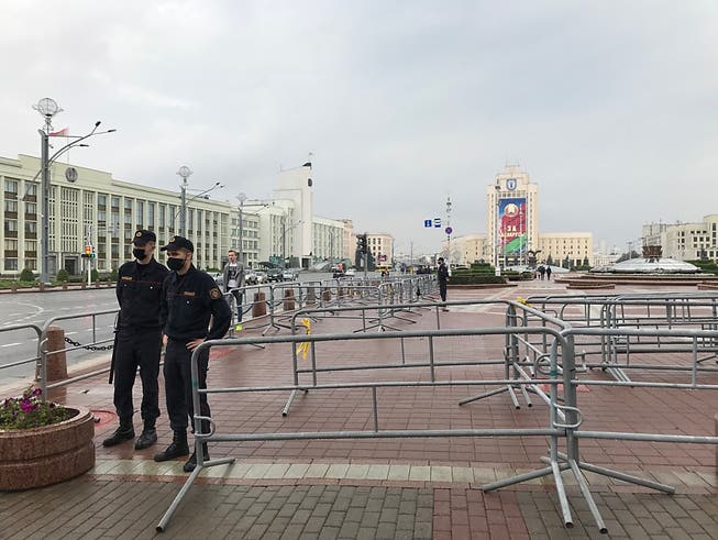 Polizisten stehen am Morgen an Metallgittern auf dem abgeriegelten Unabhängigkeitsplatz vor der geplanten grossen Sonntagsdemonstration gegen den umstrittenen belarussischen Staatschef Lukaschenko. Foto: Ulf Mauder/dpa