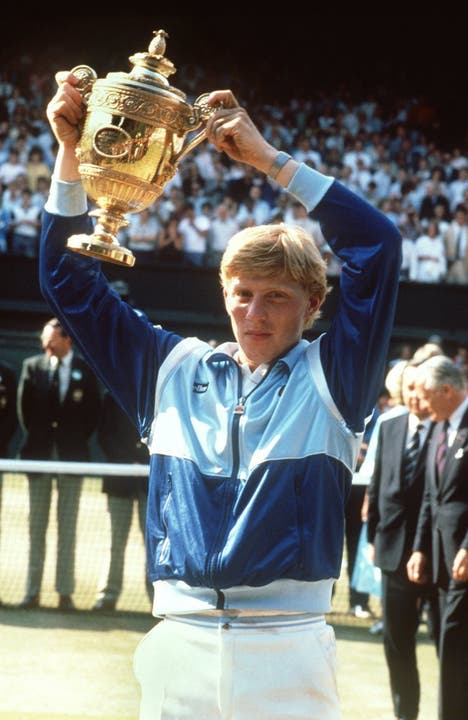 Der 17-jährige Boris Becker hält stolz seinen Pokal hoch, als er 1985 als erster Deutscher, erster Ungesetzter und als jüngster Spieler überraschend das Endspiel im Herren-Einzel bei den All-England-Championships in Wimbledon.