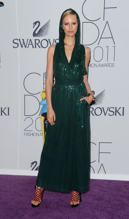 Model Anna Kournikova mit einem dunkelgrünen Wickelkleid auf dem lila Teppich