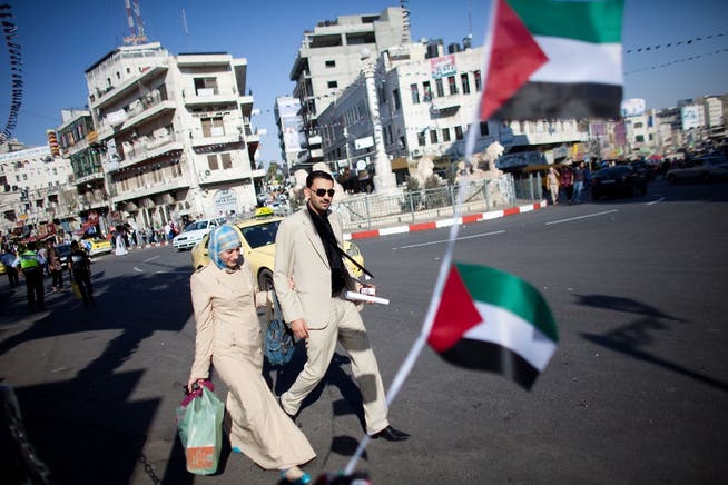Vorfreude: Palästinenser schreiten in Ramallah im Westjordanland über einen mit palästinensischen Flaggen dekorierten Kreisel. Uriel Sinai/Getty