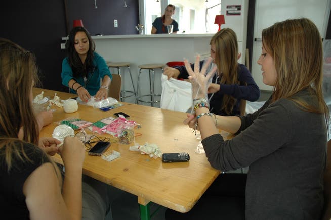 Handys und Handarbeit: Mädchentreff-Besucherinnen mit Jugendarbeiterin Bela Flütsch (hinten)
