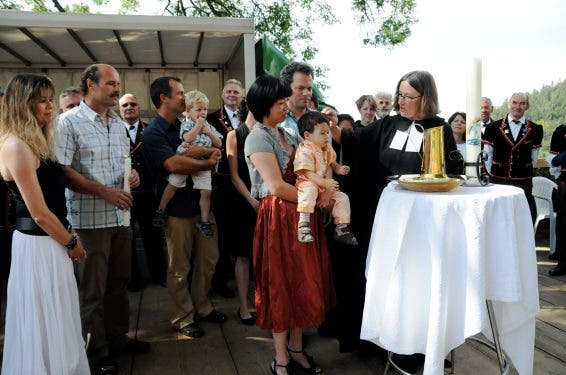 Pfarrerin Cornelia Fritz tauft Andy Aeschlimann, während Flavio Aeschlimann die Prozedur schon hinter sich hat