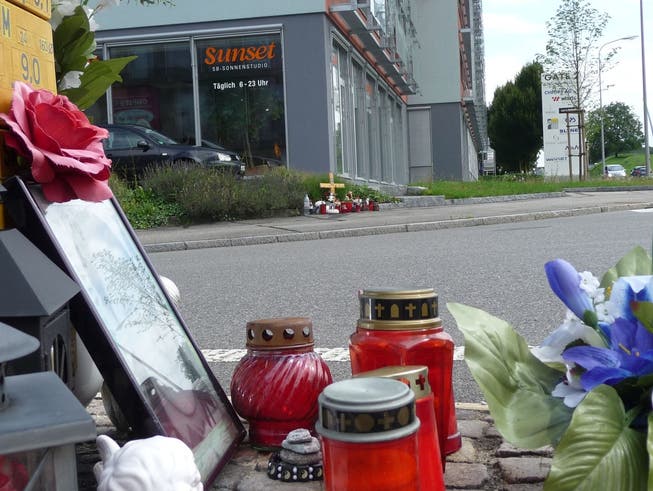 An der Mellingerstrasse in Dättwil erinnern Kerzen, Kreuz und das Konterfei des Opfers an den tödlichen Unfall vor einem Jahr.
