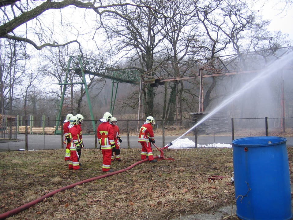 Angehende Feuerwehrleute üben den Umgang mit dem Wasserwerfer.