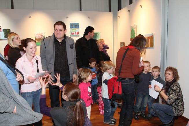 Die Kinder präsentieren ihre Bilder den Ausstellungsbesuchern.