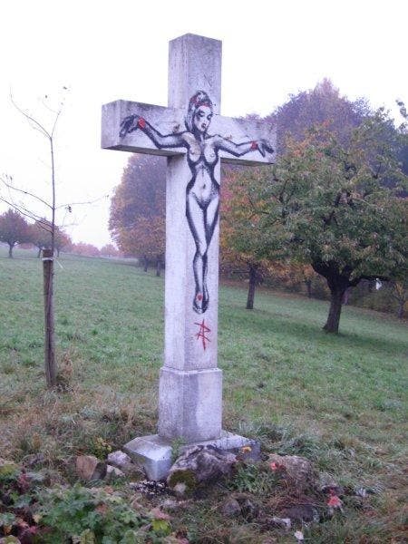 Eine nackte Frau wurde auf das beschädigte Kreuz gesprayt.