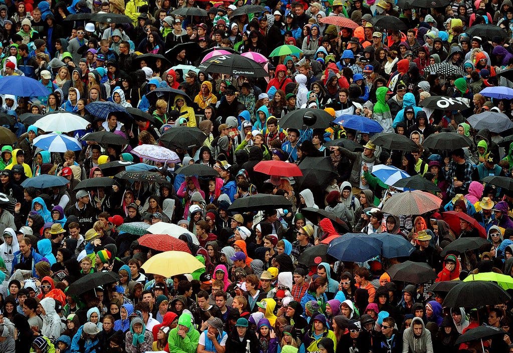 Besucherinnen und Besucher des freestyle.ch schützen sich mit Schirmen gegen den Regen am Samstag