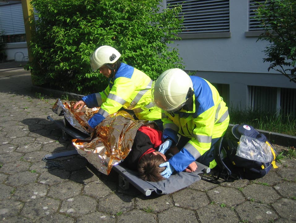 Ein verletzter Knabe wird von Sanitätern betreut