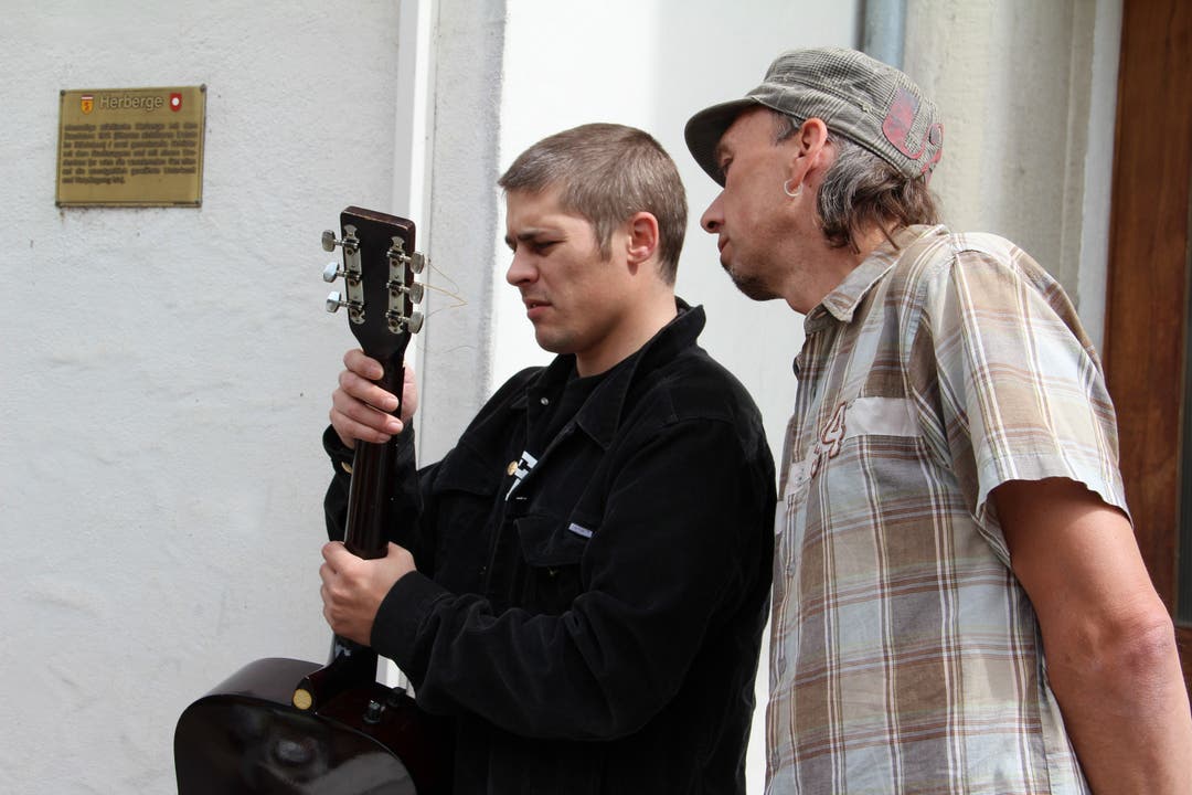 Ein Besucher interessiert sich für eine Gitarre - und wird schliesslich mit dem Verkäufer handelseinig