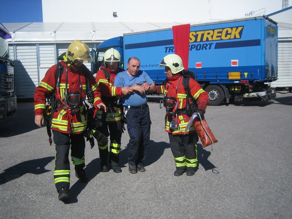 Die Feuerwehrleute bringen den Chauffeur des «verunfallten» Lastwagens aus der Gefahrenzone heraus.