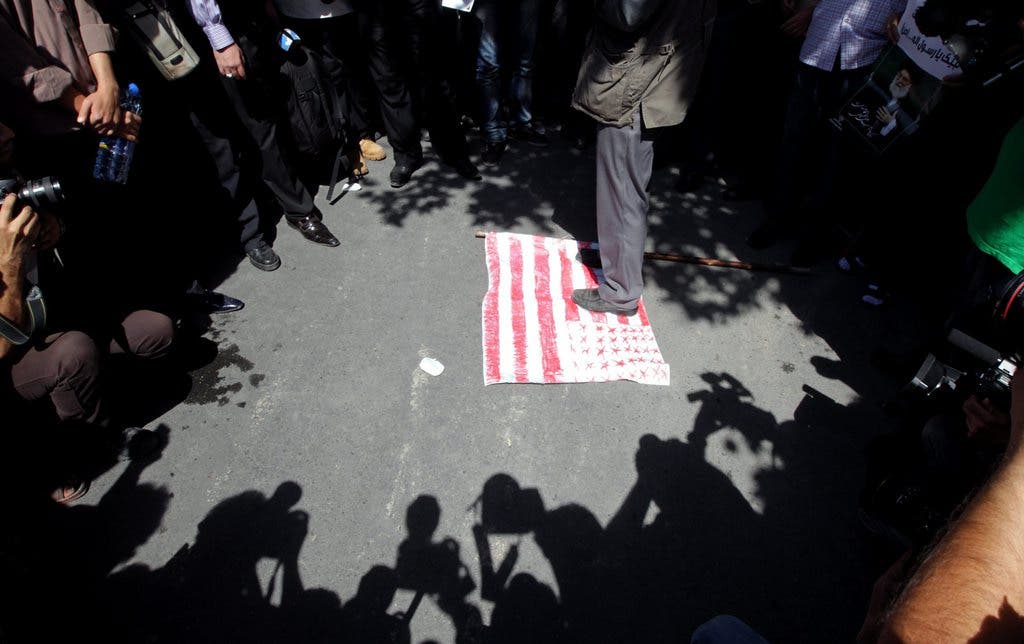 Protestierende treten vor der Schweizer Botschaft in Teheran die US-Flagge mit Füssen.