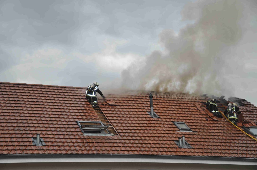 Die Feuerwehr deckt das Dach teilweise ab, um an den Brandherd zu gelangen.