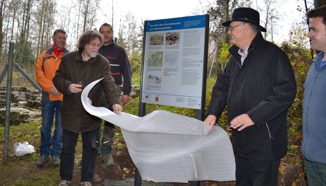 Gemeindeammann Karl Grossen (rechts) und Archäologe Peter Frey entfernen gemeinsam die Hülle der neuen Info-Tafel.