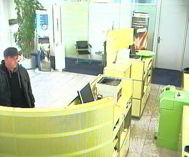 Dieser junge Mann betritt am 20. September 2012 die Raiffeisenbank-Filiale in Murgenthal, bedroht zwei Angestellte mit einer Faustfeuerwaffe und fordert Geld.