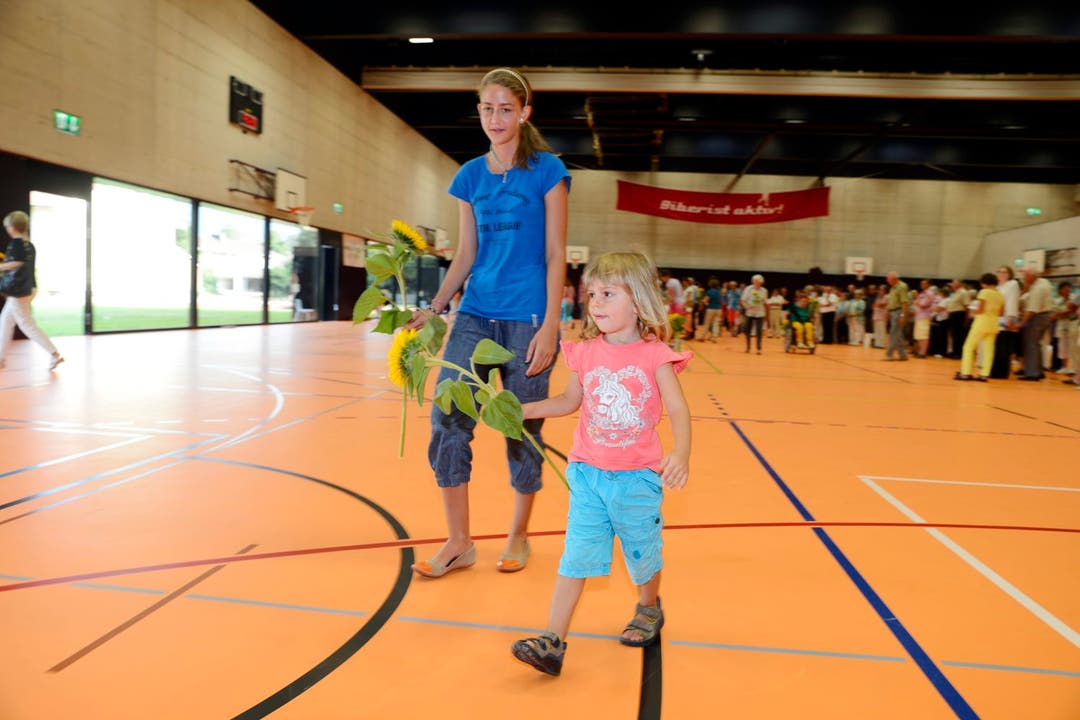 Kinder und Erwachsene schmückten am Festakt vom Sonntag die neue Biberister Dreifach-Sporthalle mit Sonnenblumen.