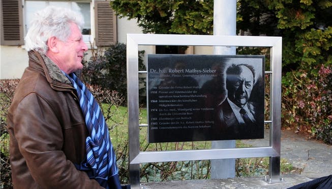 Gemeindepräsident Hans Kübli und Lisbeth Mathys enthüllen die Gedenktafel für Robert Mathys. hps