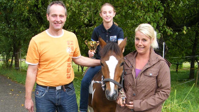 Ludivine mit ihrem Pony Jeronimo du Peruet flankiert von ihren Eltern Sandra und Herbert Brunner-Froidevaux.