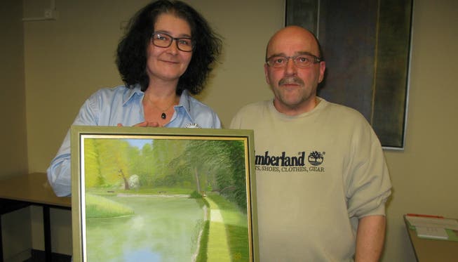 Das frischgebackene Ehrenmitglied Romeo Gorza erhält aus den Händen von Vorstandsmitglied Silvia Aerni ein Bild vom Weiher im Trimbacher «Graben».