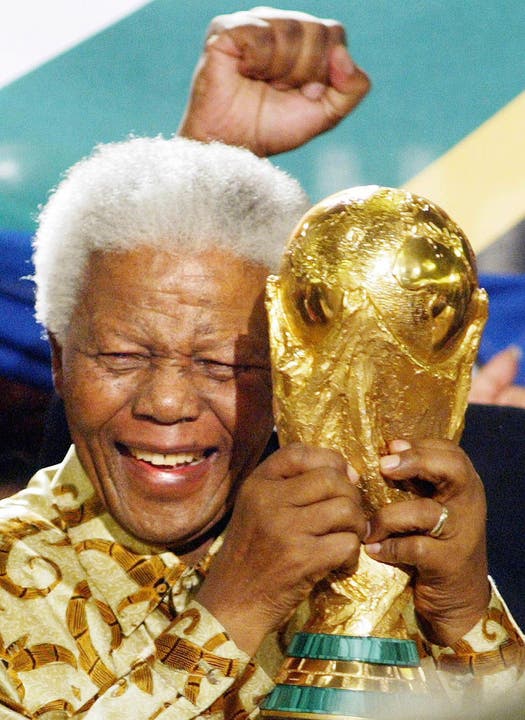 Mandela hält nach der Vergabe der Fussball-WM 2010 an Südafrika den WM-Pokal in der Hand.