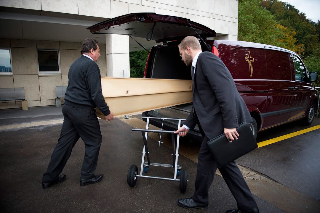 Schildknecht und Kretz laden den Sarg mit der Verstorbenen in den Leichenwagen.
