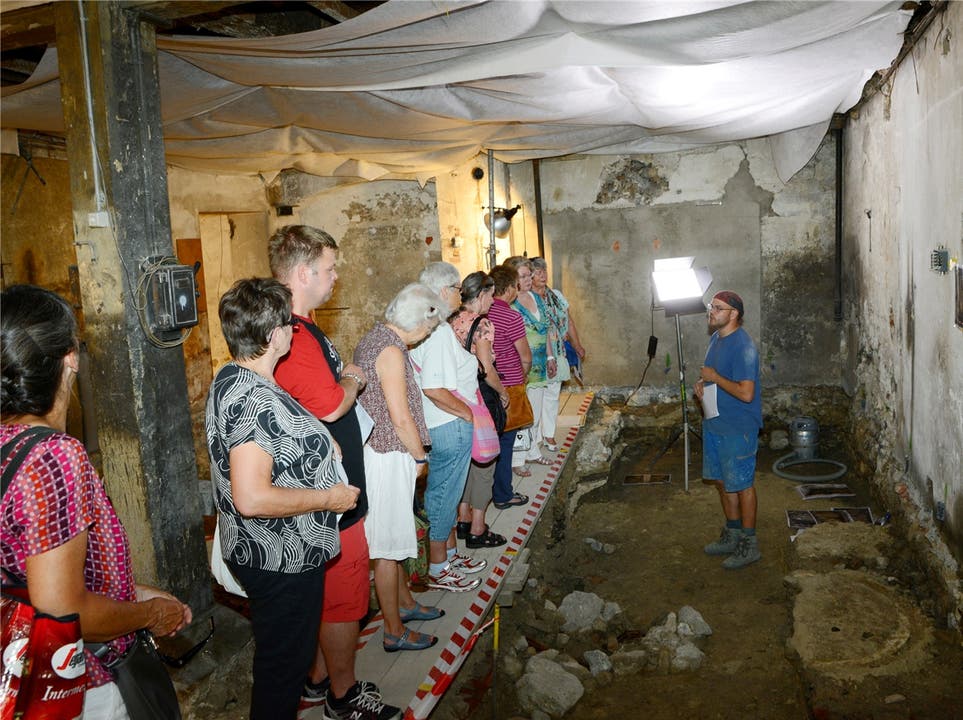 Eine Besuchergruppe lässt sich die Grabungsstelle erklären.