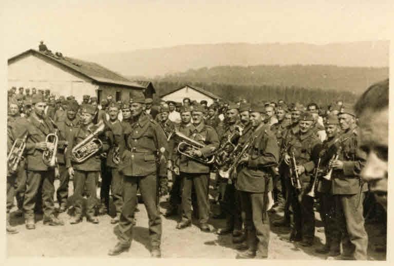 Schweizer Soldaten und ein Armeespiel verabschieden Flüchtlinge am Kriegsende, 1945