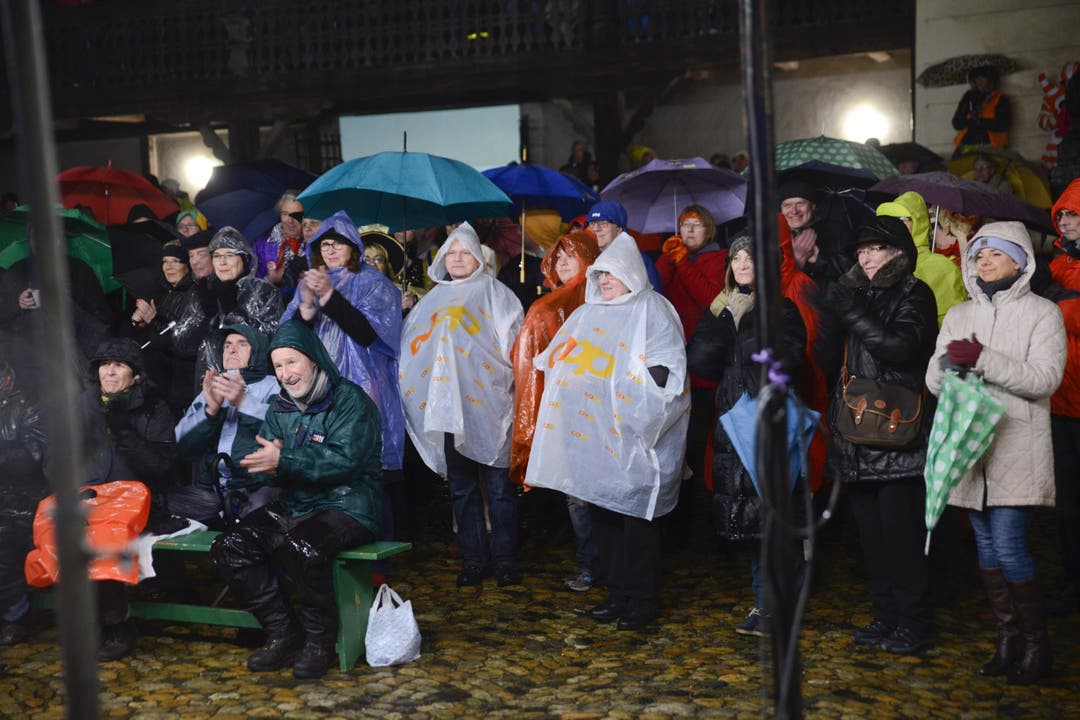 Die Zuschauer schützten sich mit Regenmänteln und Schirmen