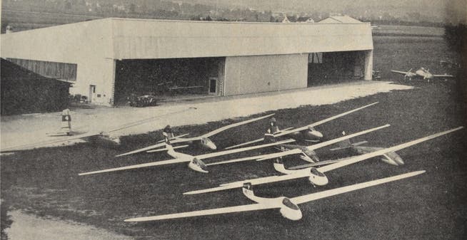 Die Flotte der Segelflugzeuge (links). Der grosse Hangar im Hintergrund existiert noch, steht heute aber nicht mehr am Rand des Flugplatzes, sondern in der Mitte. Auf dem Titelblatt der «Aero Revue» von 1964 (r.) sind neben dem Flugplatz auch das Schwimmbad sowie die neue Tribüne des Stadions Brühl zu erkennen.Archiv PBG