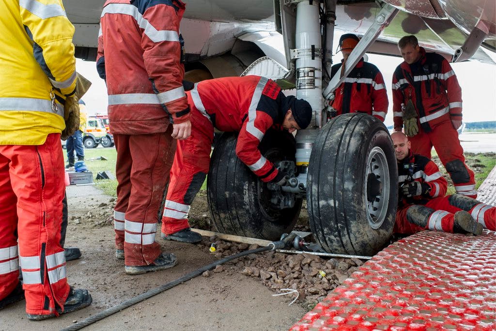 Mitarbeiter von Schutz und Rettung Zürich versuchen die gestrandete Boeing 737 der türkischen Tailwind-Airline aus dem Dreck zu ziehen